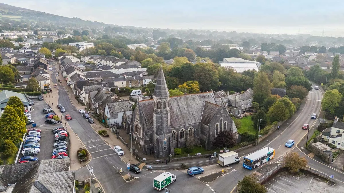 Aerial view of a church and village street in the South Hams