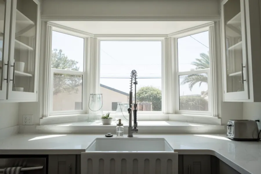 A kitchen with a bay window over the sink